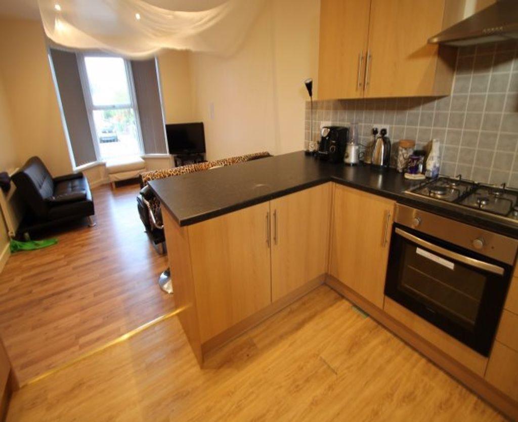 A modern kitchen area with wooden flooring and ...