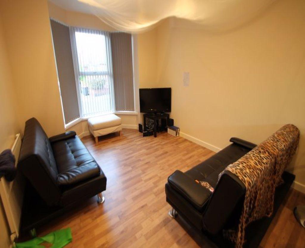 A cozy living room featuring two black sofas ar...