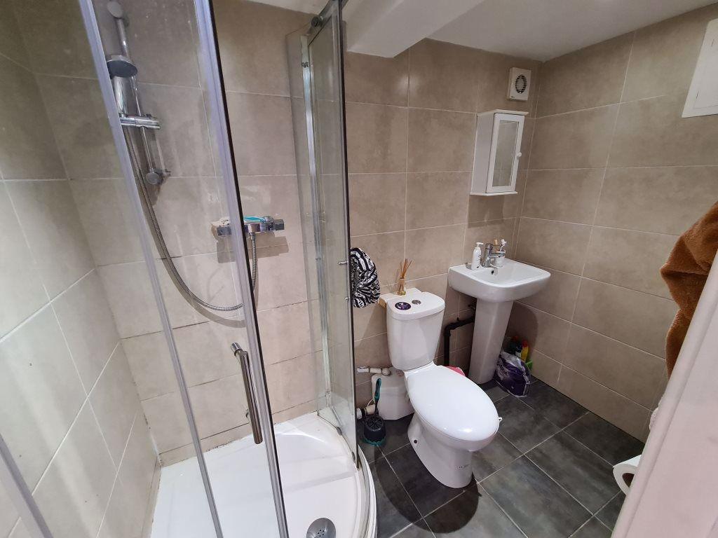 A modern bathroom featuring a glass-enclosed sh...