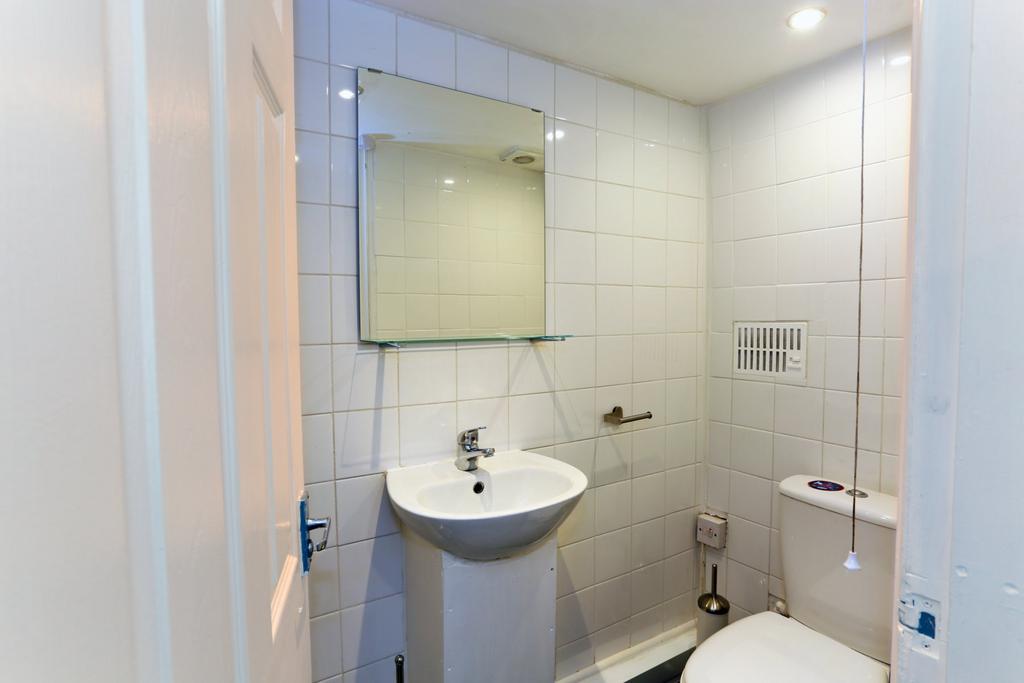 A clean and modern bathroom featuring white til...