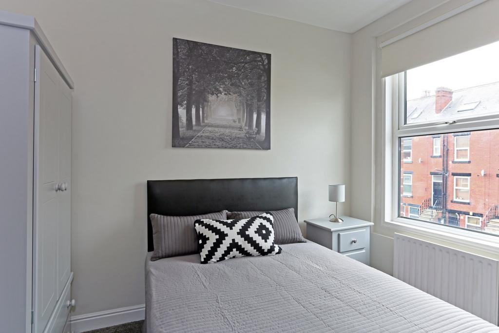 A cozy and well-lit single bedroom featuring a ...