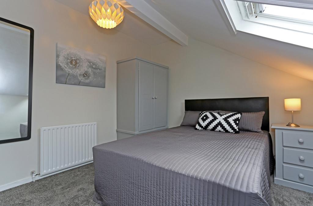 Bright and cozy master bedroom featuring a comf...