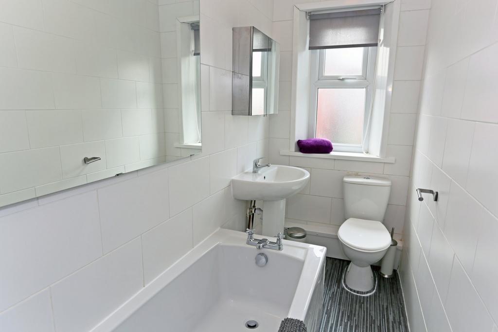 Bright and clean bathroom featuring a bathtub, ...