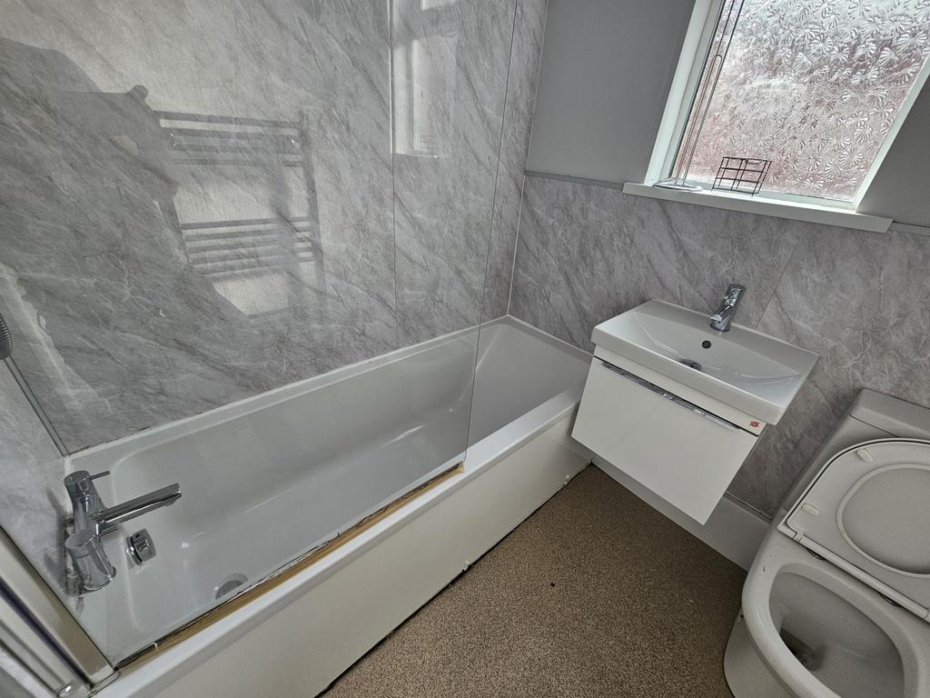 A clean and modern bathroom with a large bathtu...