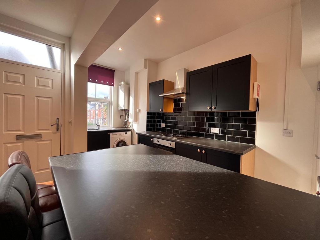 Modern kitchen with sleek black countertops and...