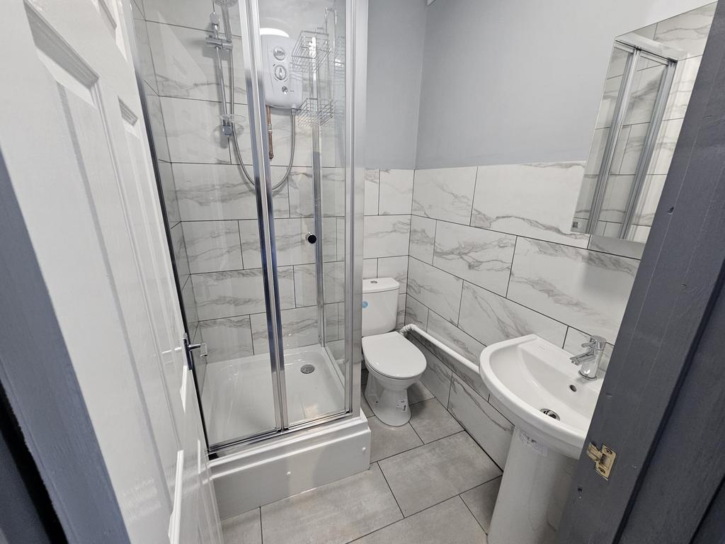 A modern, clean bathroom suite featuring a glas...