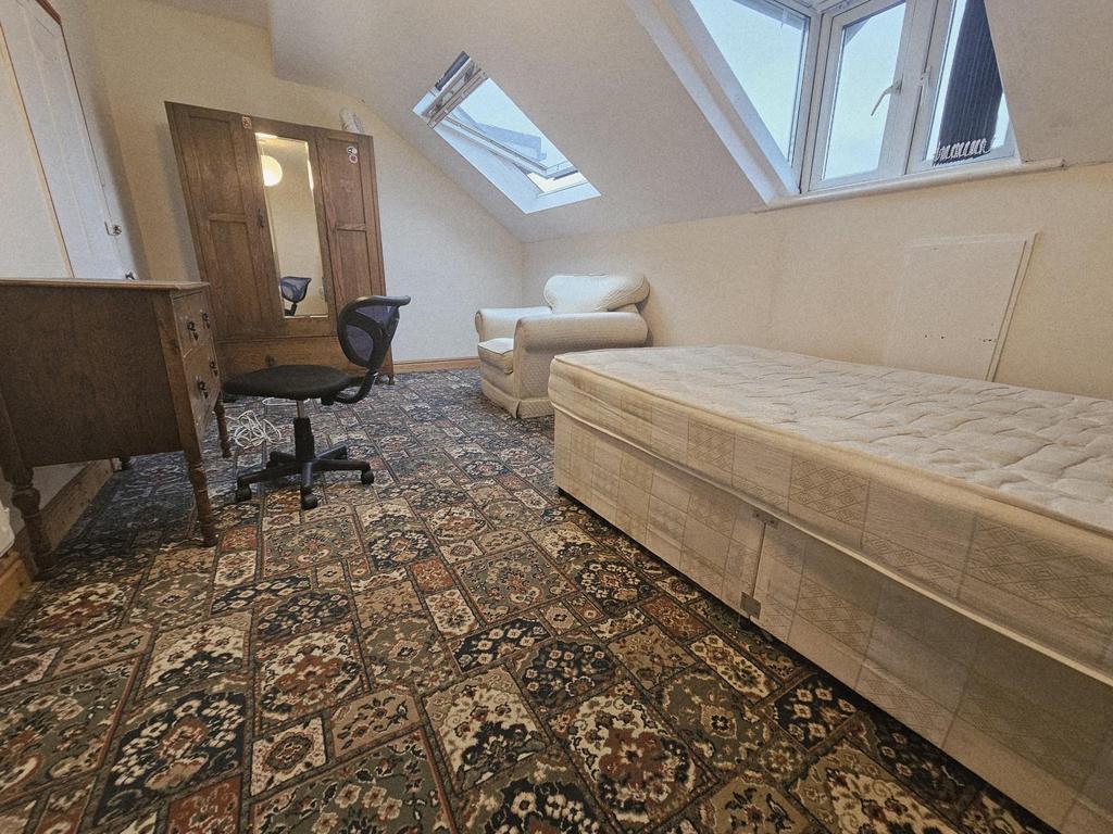 A spacious master bedroom featuring a large bed...