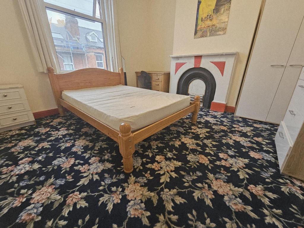 A spacious bedroom featuring a solid wooden bed...