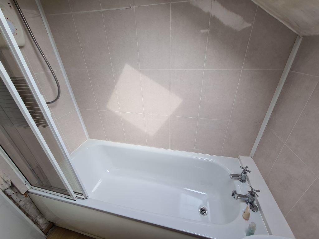 A clean and bright bathroom suite featuring a w...