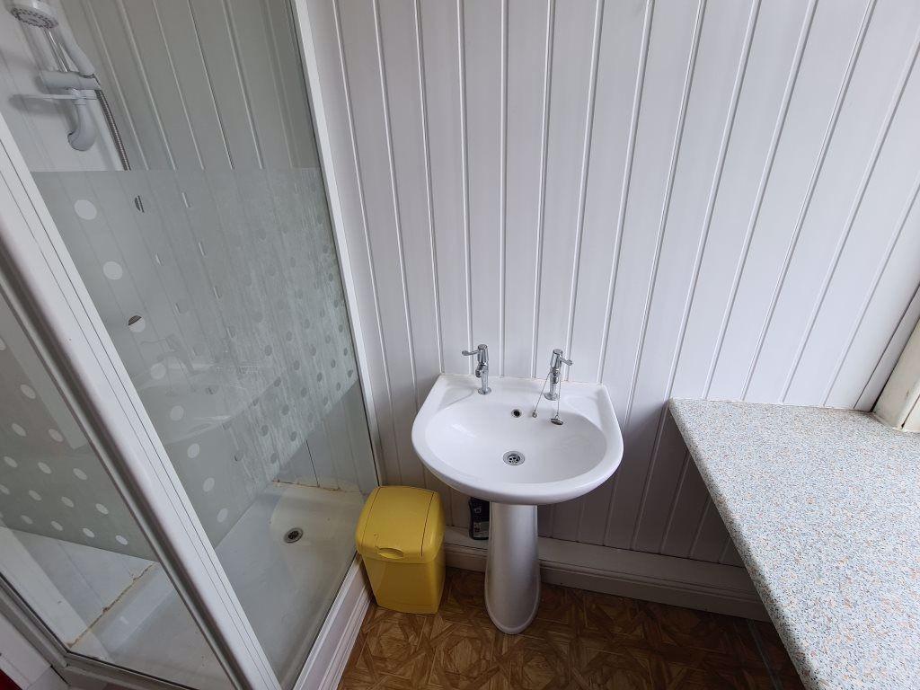 A bright and tidy bathroom featuring a corner s...