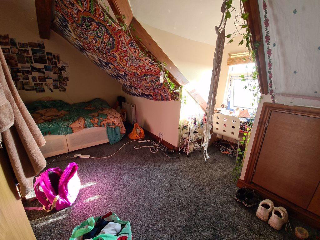Bright and cozy single bedroom featuring a slop...