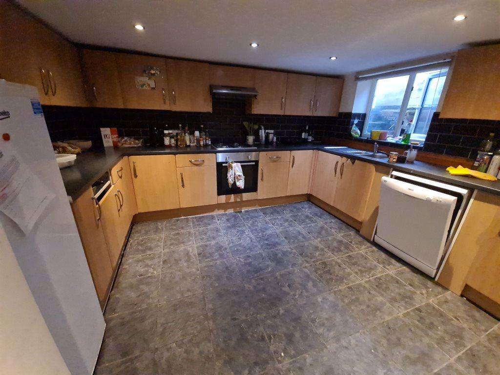A spacious, modern kitchen featuring ample wood...
