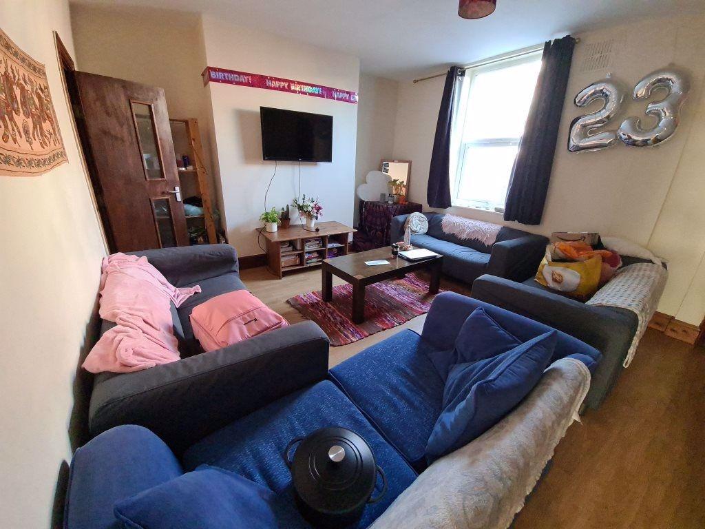 A cozy living room featuring multiple sofas arr...