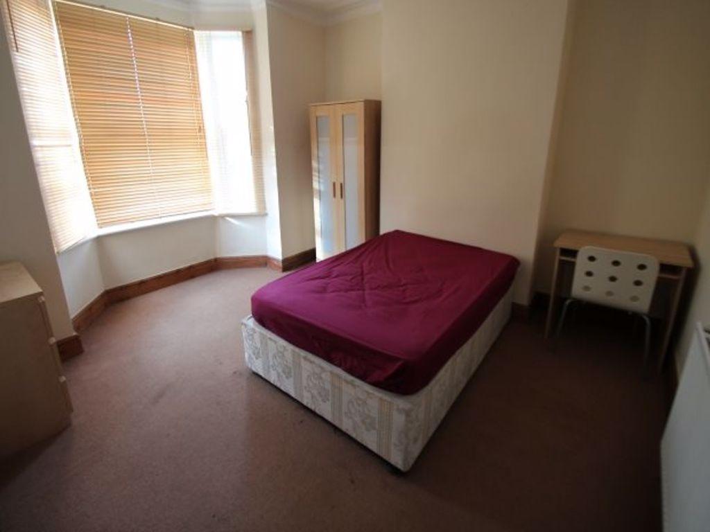 A bright double bedroom featuring a comfortable...