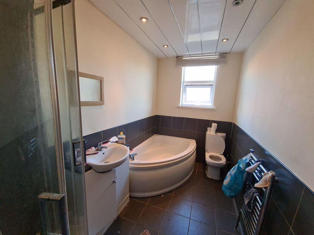 A modern bathroom suite featuring a corner bath...