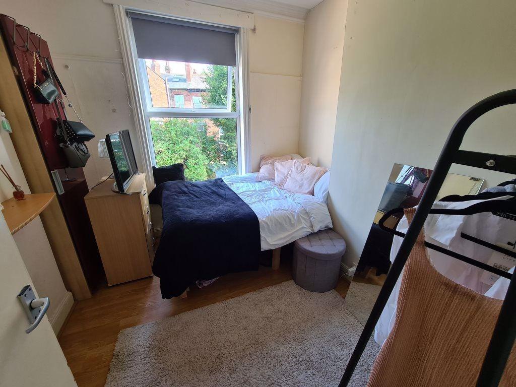 A cozy single bedroom featuring a single bed po...