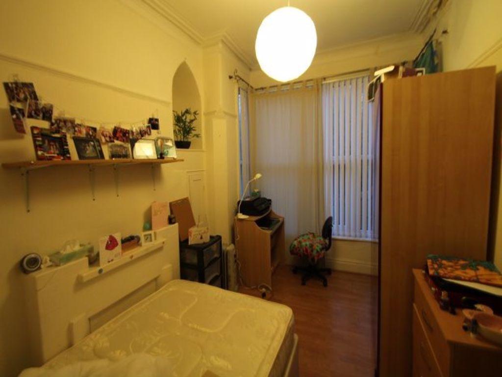 A cozy single bedroom featuring a neatly made b...