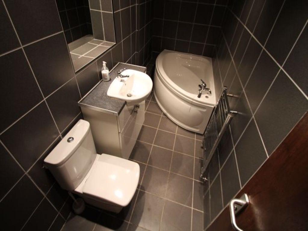 A modern bathroom suite featuring a corner bath...