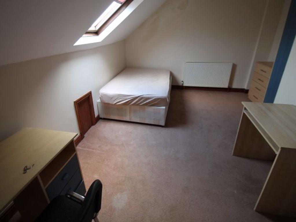 A cozy single bedroom with a sloped ceiling fea...