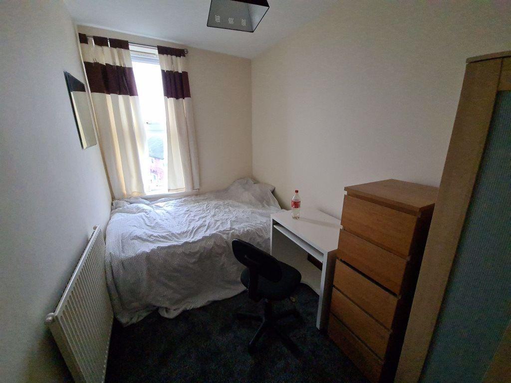 Cozy single bedroom featuring a comfortable bed...
