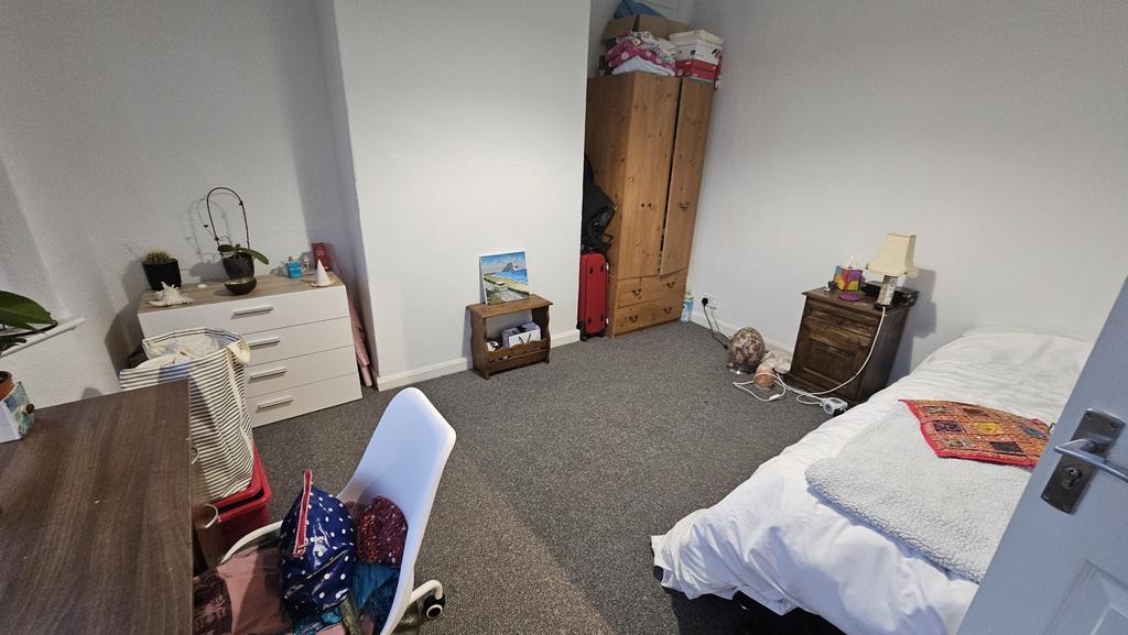 A tidy single bedroom featuring a single bed, d...