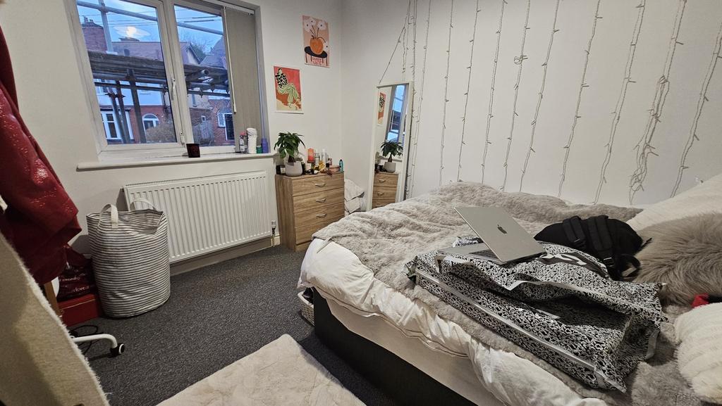 Cozy single bedroom featuring a large window th...