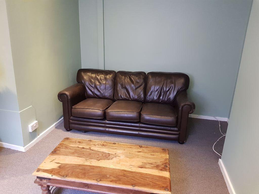 Cozy living room featuring a classic brown leat...