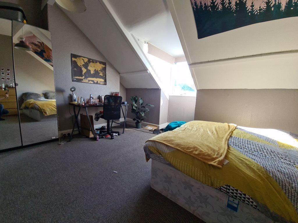 A cozy single bedroom featuring a large skyligh...