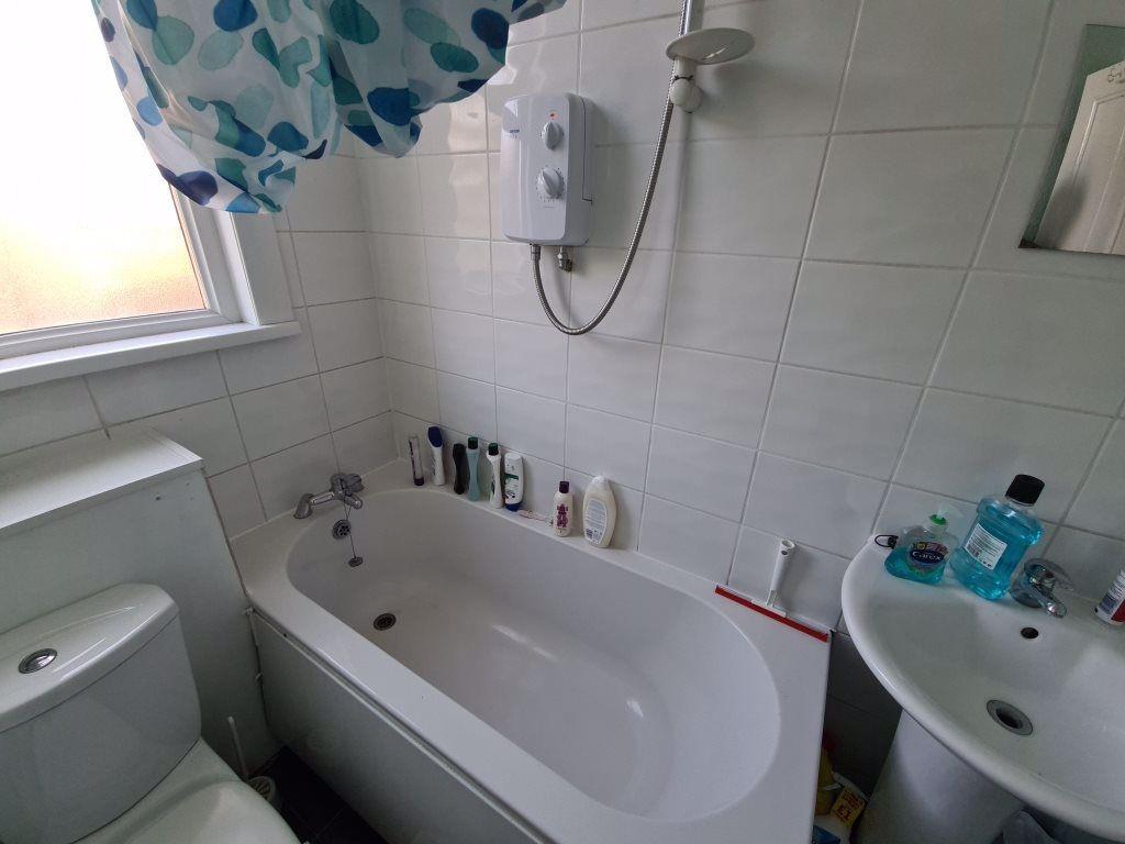 Bright and clean bathroom suite featuring a bat...
