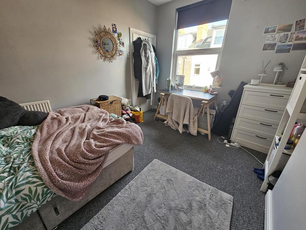 Cozy single bedroom featuring a comfortable bed...