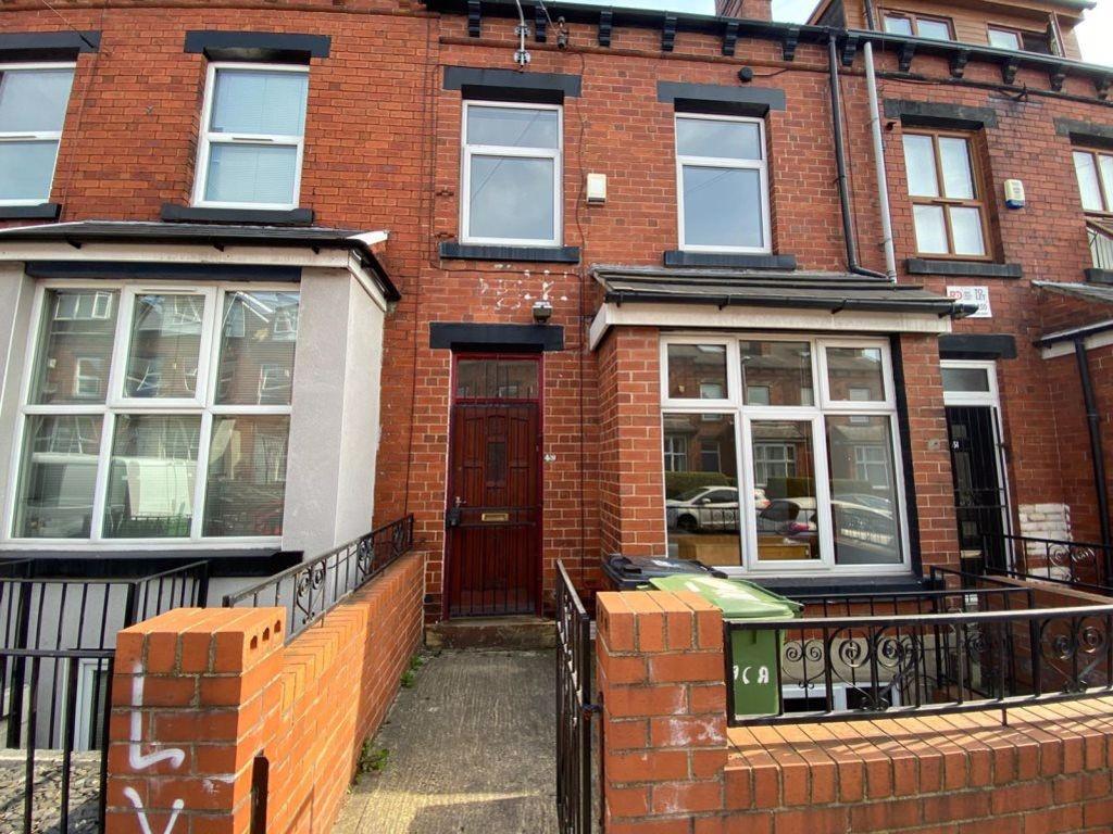 A charming red-brick terraced house featuring a...