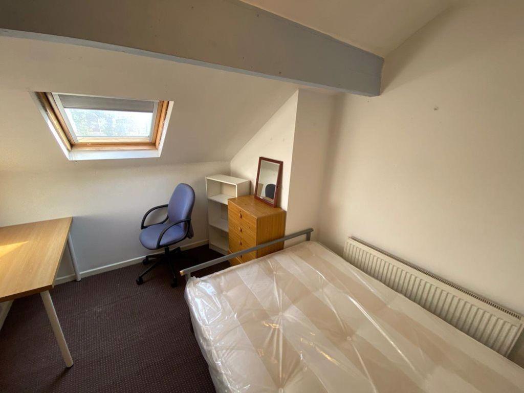 A cozy single bedroom featuring a comfortable b...