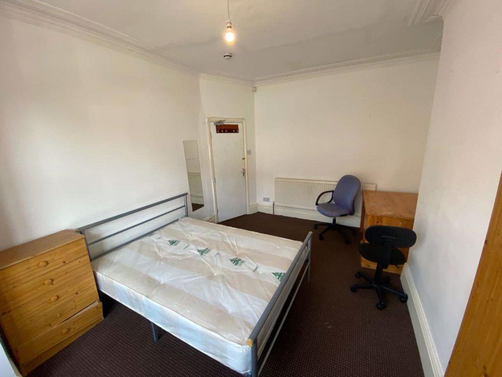 A tidy single bedroom featuring a metal bed fra...