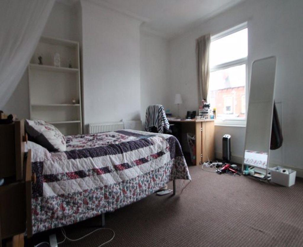 A cozy single bedroom featuring a comfortable b...