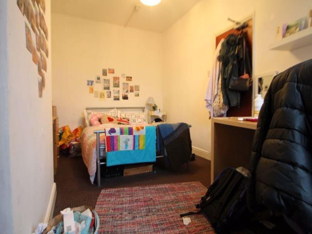 A cozy, well-organized bedroom featuring a sing...