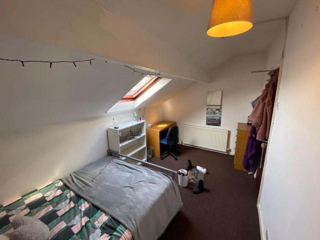 Cozy single bedroom featuring a skylight window...