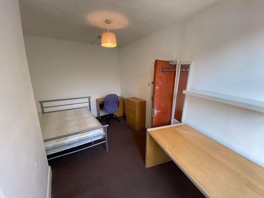 A tidy and simple single bedroom featuring a me...