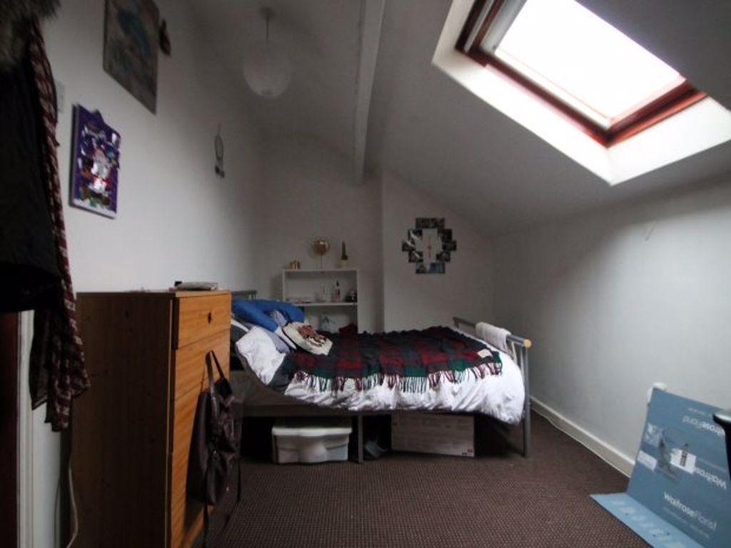 A cozy single bedroom featuring a skylight wind...