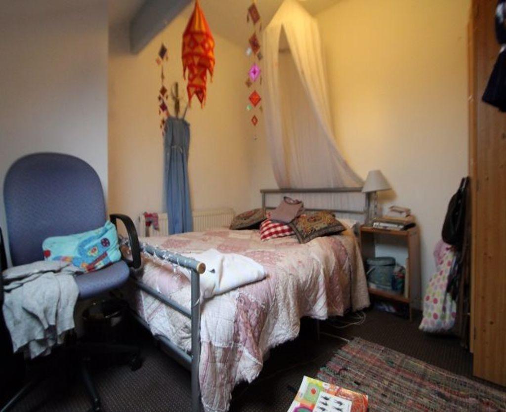 Cozy single bedroom featuring a comfortable bed...