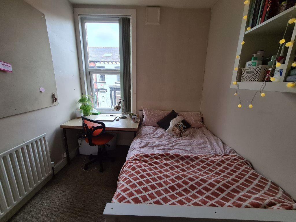 Cozy single bedroom featuring a neatly made bed...