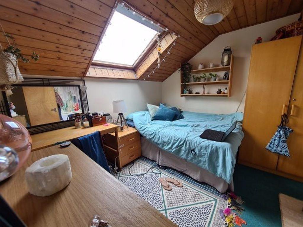 A cozy attic bedroom featuring a comfortable si...