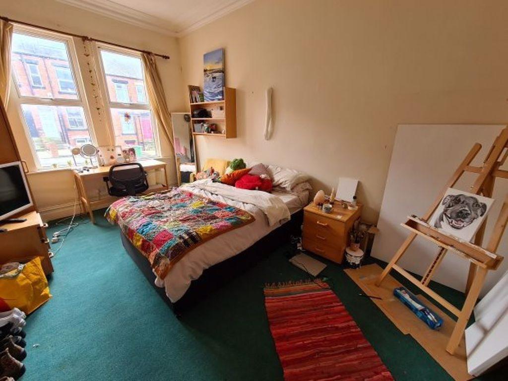 Bright and cozy bedroom featuring a comfortable...