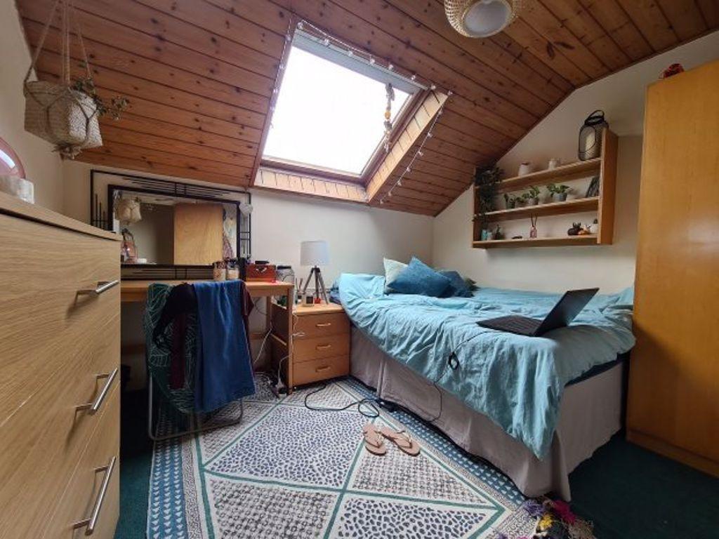 Cozy single bedroom featuring a skylight that b...