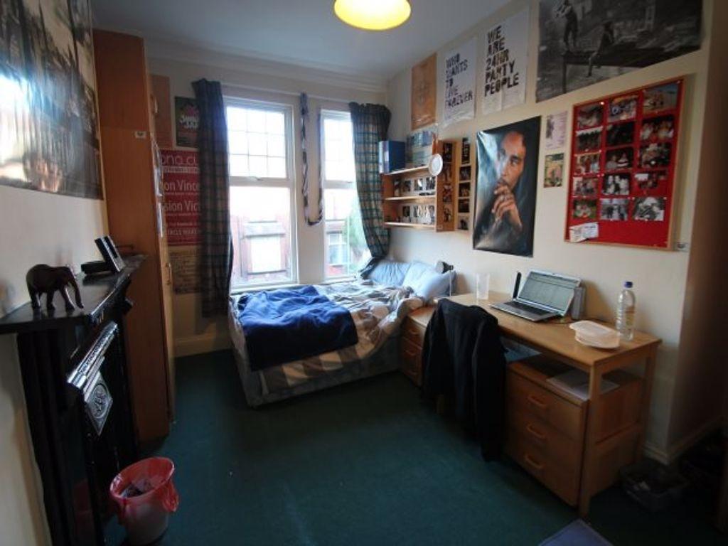 A cozy single bedroom featuring a comfortable b...