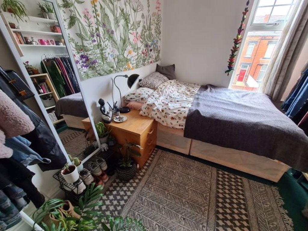 A cozy and well-lit bedroom featuring a neatly ...