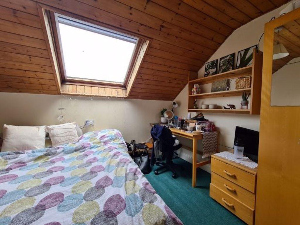 Cozy double bedroom with a colorful quilted bed...