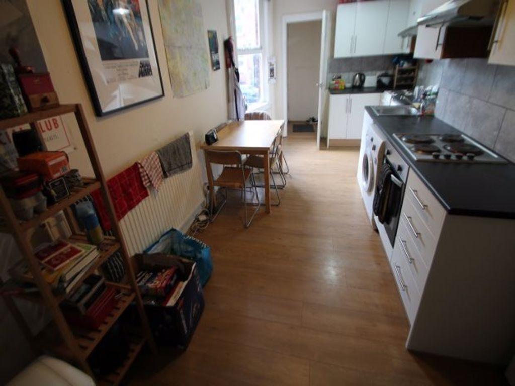 Modern kitchen with clean wooden flooring, whit...