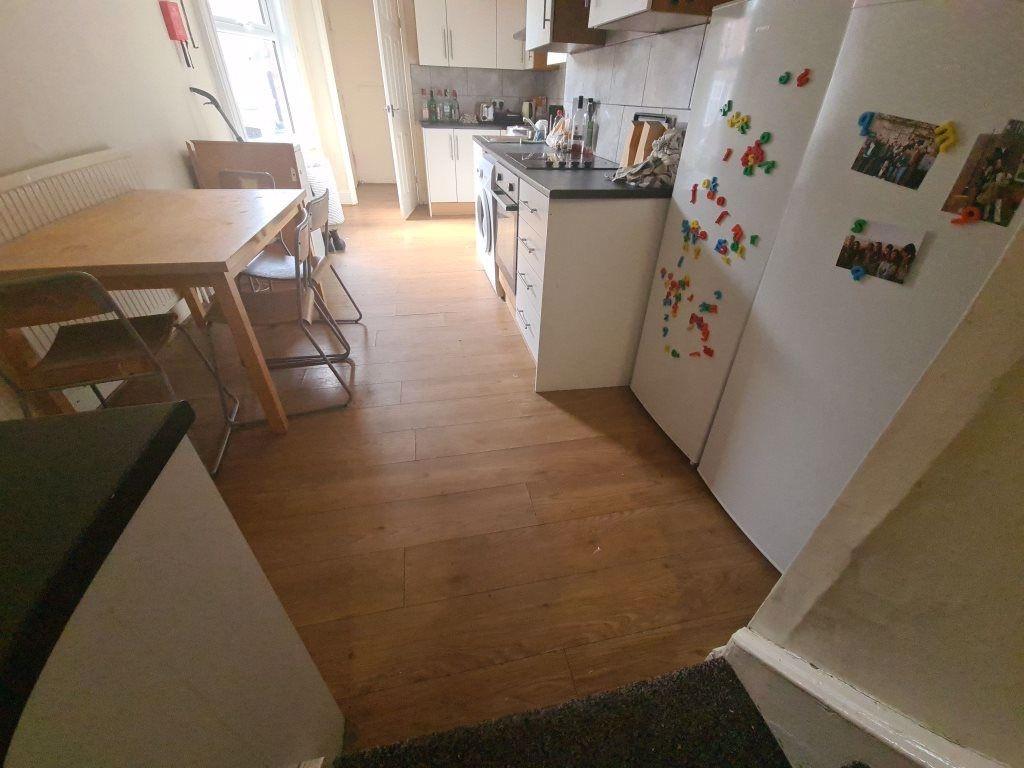A bright kitchen featuring wooden flooring, a w...