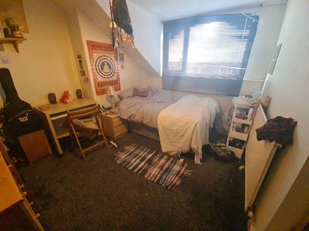 A cozy single bedroom featuring a comfortable b...