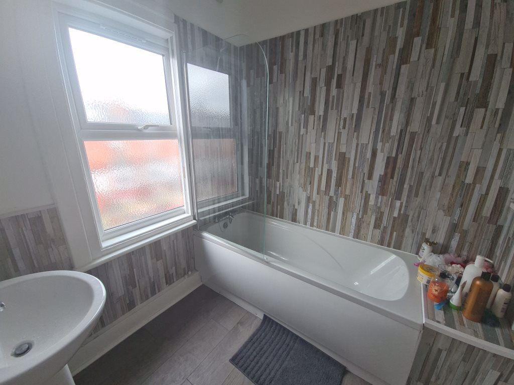 A bright bathroom suite featuring a modern bath...